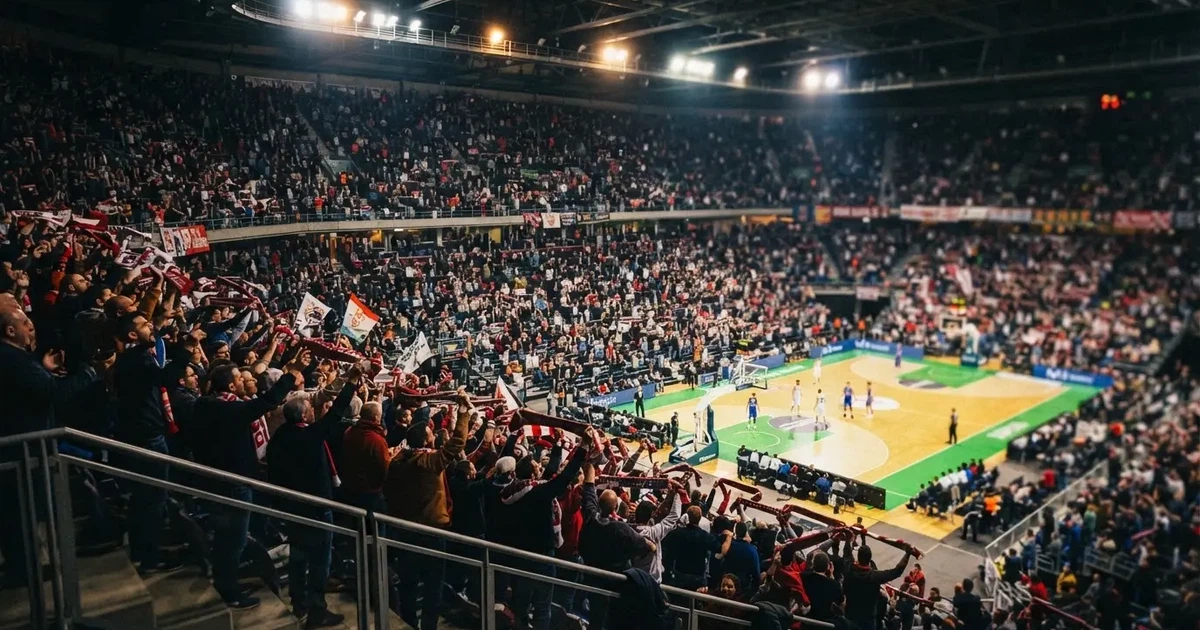 Een volle sporthal onder schijnwerpers, van grote afstand gefotografeerd