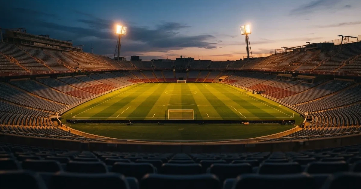 Een leeg voetbalstadion met lichtmasten bij schemering