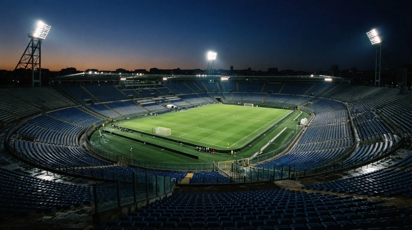 Een leeg voetbalstadion met lichtmasten bij schemering